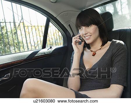 Mid adult woman at back seat of car, using mobile phone View Large Photo Image Stock Image - Mid adult woman at back seat of car, using mobile phone. Fotosearch