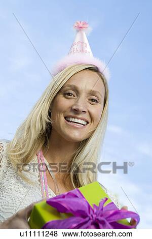 Mid-adult woman holding birthday present View Large Photo Image Stock Photo - Mid-adult woman holding birthday present. Fotosearch