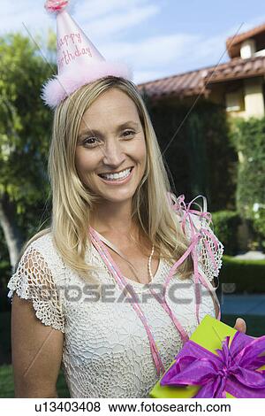 Mid-adult woman holding birthday present View Large Photo Image Stock Photo - Mid-adult woman holding birthday present. Fotosearch