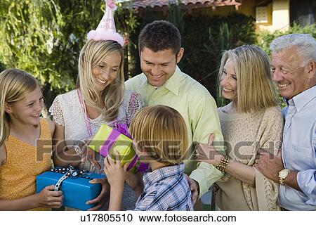 Stock Image - Mid-adult woman receiving birthday presents. Fotosearch