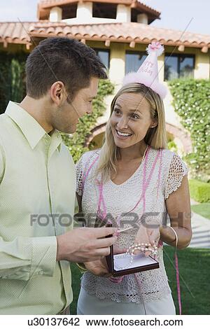 Mid-adult woman receiving pearl necklace as birthday present View Large Photo Image Stock Image - Mid-adult woman receiving pearl necklace as birthday present. Fotosearch