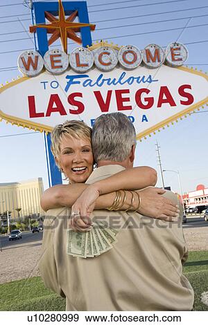 Middle-aged couple embracing in front of Welcome to Las Vegas sign View Large Photo Image Stock Photo - Middle-aged couple embracing in front of Welcome to Las Vegas sign. Fotosearch