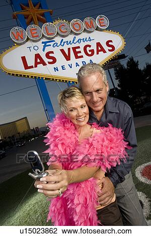 Middle-aged couple in front of Welcome to Las Vegas sign View Large Photo Image Stock Image - Middle-aged couple in front of Welcome to Las Vegas sign. Fotosearch