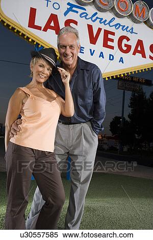 Middle-aged couple in front of Welcome to Las Vegas sign, portrait View Large Photo Image Stock Photography - Middle-aged couple in front of Welcome to Las Vegas sign, portrait. Fotosearch