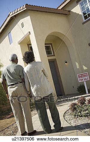 Middle-aged couple looking at newly build house, back view View Large Photo Image Stock Photograph - Middle-aged couple looking at newly build house, back view. Fotosearch