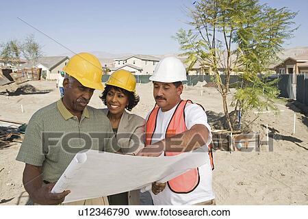 Middle-aged couple watching blueprints with surveyor View Large Photo Image Stock Image - Middle-aged couple watching blueprints with surveyor. Fotosearch