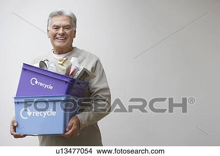 Middle-aged man holding recycling containers, smiling View Large Photo Image Picture - Middle-aged man holding recycling containers, smiling. Fotosearch