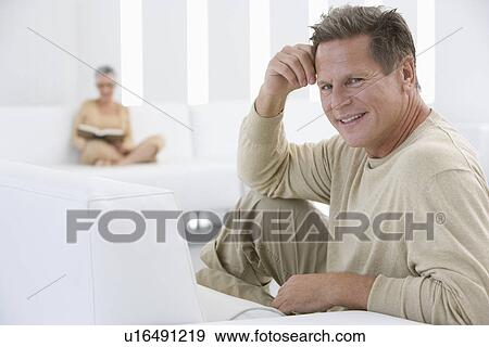 Stock Photo - Middle-aged man relaxing on sofa. Fotosearch