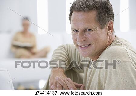Middle-aged man relaxing on sofa View Large Photo Image Stock Photo - Middle-aged man relaxing on sofa. Fotosearch