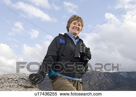 Middle-aged woman holding binoculars View Large Photo Image Stock Photography - Middle-aged woman holding binoculars. Fotosearch
