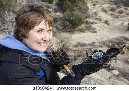 Middle-aged woman holding compass View Large Photo Image Stock Image - Middle-aged woman holding compass. Fotosearch
