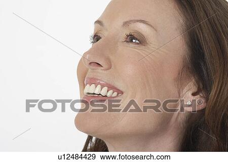 Middle-aged woman smiling big, looking up, side view, close-up View Large Photo Image Stock Photo - Middle-aged woman smiling big, looking up, side view, close-up. Fotosearch