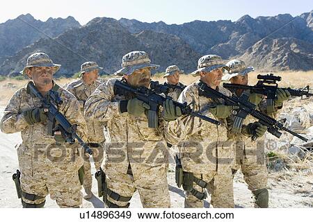 Stock Photo - Military soldiers on patrol in mountains. Fotosearch
