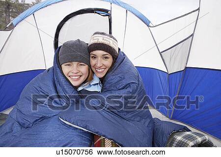 Stock Photograph - Mother and daughter (10-12) in tent, (portrait). Fotosearch