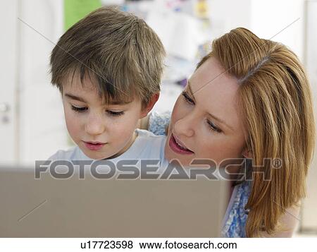 Stock Photo - Mother and son (3-6) using laptop, indoors. Fotosearch