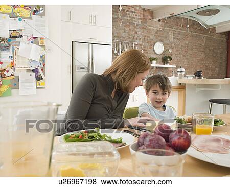 Stock Photo - Mother and Son at Dinner Table. Fotosearch