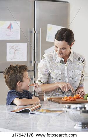 Mother and Son chopping vegetables in kitchen View Large Photo Image Stock Photo - Mother and Son chopping vegetables in kitchen. Fotosearch