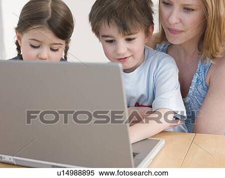 Stock Photography - Mother Helping Children Use Laptop. Fotosearch