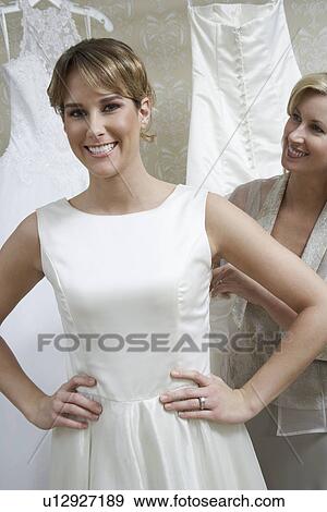 Stock Photo - Mother helping daughter to dress. Fotosearch