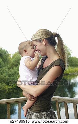 Mother holding daughter by lake, half length View Large Photo Image Stock Photography - Mother holding daughter by lake, half length. Fotosearch