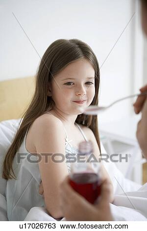 Mother preparing cough syrup for daughter in bedroom View Large Photo Image Stock Image - Mother preparing cough syrup for daughter in bedroom. Fotosearch