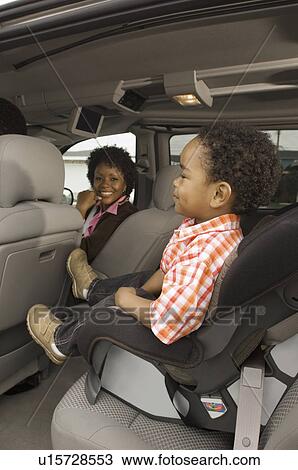 Mother smiling at young son on car seat View Large Photo Image Stock Image - Mother smiling at young son on car seat. Fotosearch