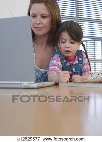 Mother Using Laptop While Daughter Colors View Large Photo Image Stock Photo - Mother Using Laptop While Daughter Colors. Fotosearch