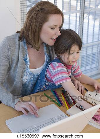 Mother Using Laptop While Daughter Colors View Large Photo Image Stock Photo - Mother Using Laptop While Daughter Colors. Fotosearch