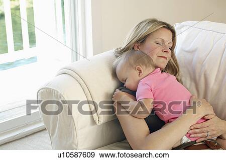 Mother with baby sleeping on sofa View Large Photo Image Stock Photo - Mother with baby sleeping on sofa. Fotosearch
