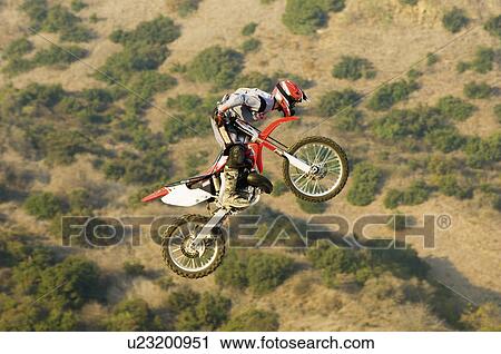 Motocross racer in mid-air over desert View Large Photo Image Stock Image - Motocross racer in mid-air over desert. Fotosearch