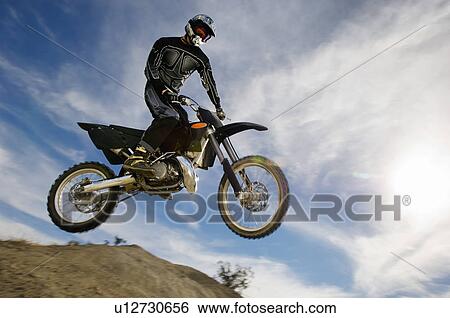 Stock Photograph - Motocross racer in mid-air. Fotosearch