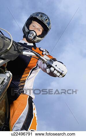 Motocross racer on bike, (portrait), (low angle view) View Large Photo Image Stock Image - Motocross racer on bike, (portrait), (low angle view). Fotosearch