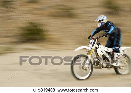 Motocross racer travelling at speed, outdoors View Large Photo Image Stock Photo - Motocross racer travelling at speed, outdoors. Fotosearch
