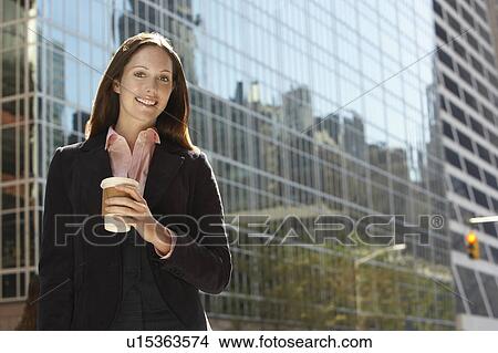 Office worker with drink outside office building, portrait View Large Photo Image Picture - Office worker with drink outside office building, portrait. Fotosearch