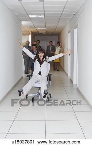 Office workers playing on office chairs in hallway View Large Photo Image Stock Image - Office workers playing on office chairs in hallway. Fotosearch