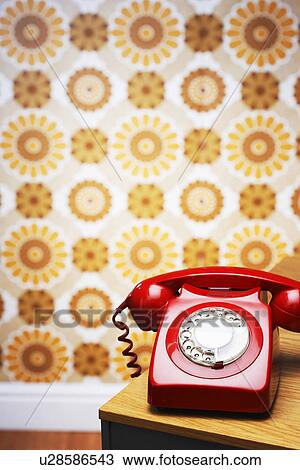 Old fashioned red telephone on table in front of flowery wallpaper View Large Photo Image Stock Image - Old fashioned red telephone on table in front of flowery wallpaper. Fotosearch
