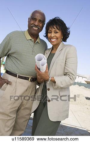 Outdoor portrait of couple with blueprints View Large Photo Image Stock Photo - Outdoor portrait of couple with blueprints. Fotosearch
