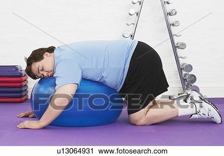 Overweight Man sleeping on Exercise Ball in health club View Large Photo Image Stock Image - Overweight Man sleeping on Exercise Ball in health club. Fotosearch