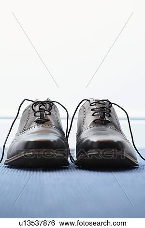 Stock Photograph - Pair of wing-tip shoes, front view. Fotosearch
