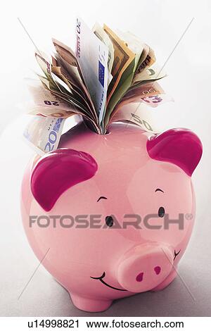 Stock Image - Paper money coming out of piggy bank. Fotosearch