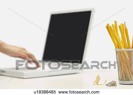 Pencils and sharpener by person using laptop, focus on foreground View Large Photo Image Stock Photography - Pencils and sharpener by person using laptop, focus on foreground. Fotosearch