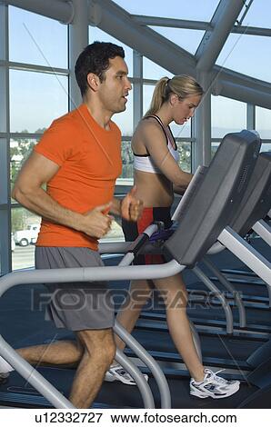 Stock Photo - People Exercising on Treadmills in Health Club. Fotosearch