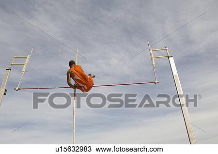 Pole vaulted in mid-air, low angle view View Large Photo Image Stock Image - Pole vaulted in mid-air, low angle view. Fotosearch