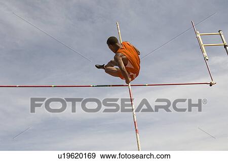 Pole vaulted in mid-air, low angle view View Large Photo Image Stock Photo - Pole vaulted in mid-air, low angle view. Fotosearch