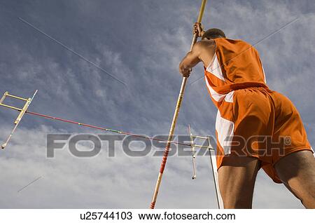 Stock Image - Pole-vaulter preparing for jump. Fotosearch