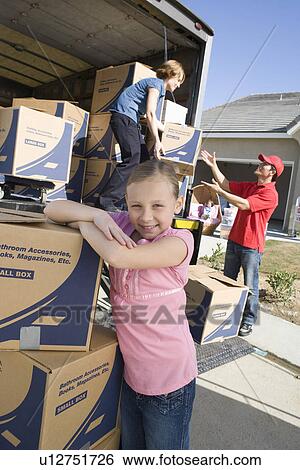 Stock Photograph - Portrait of girl (7-9) by truck of cardboard boxes. Fotosearch