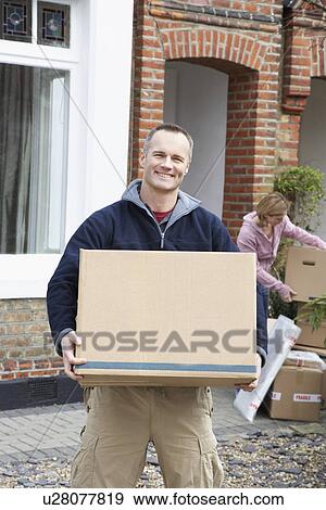 Portrait of man holding box outside house View Large Photo Image Stock Photo - Portrait of man holding box outside house. Fotosearch