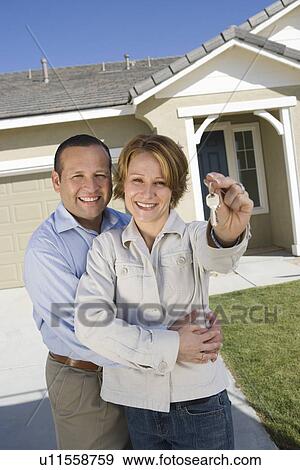 Portrait of mid-adult couple with keys to new house View Large Photo Image Stock Photo - Portrait of mid-adult couple with keys to new house. Fotosearch