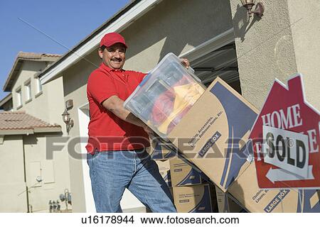 Picture - Portrait of mid-adult man moving into house. Fotosearch