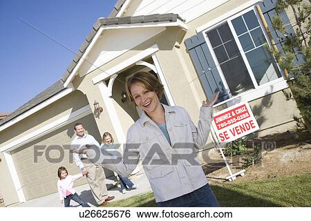 Stock Photograph - Portrait of mid-adult woman in front of new house. Fotosearch